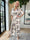 Pams Leafage Jumpsuit - Elastisk jumpsuit i lövmönster med guldfärgade tofsar