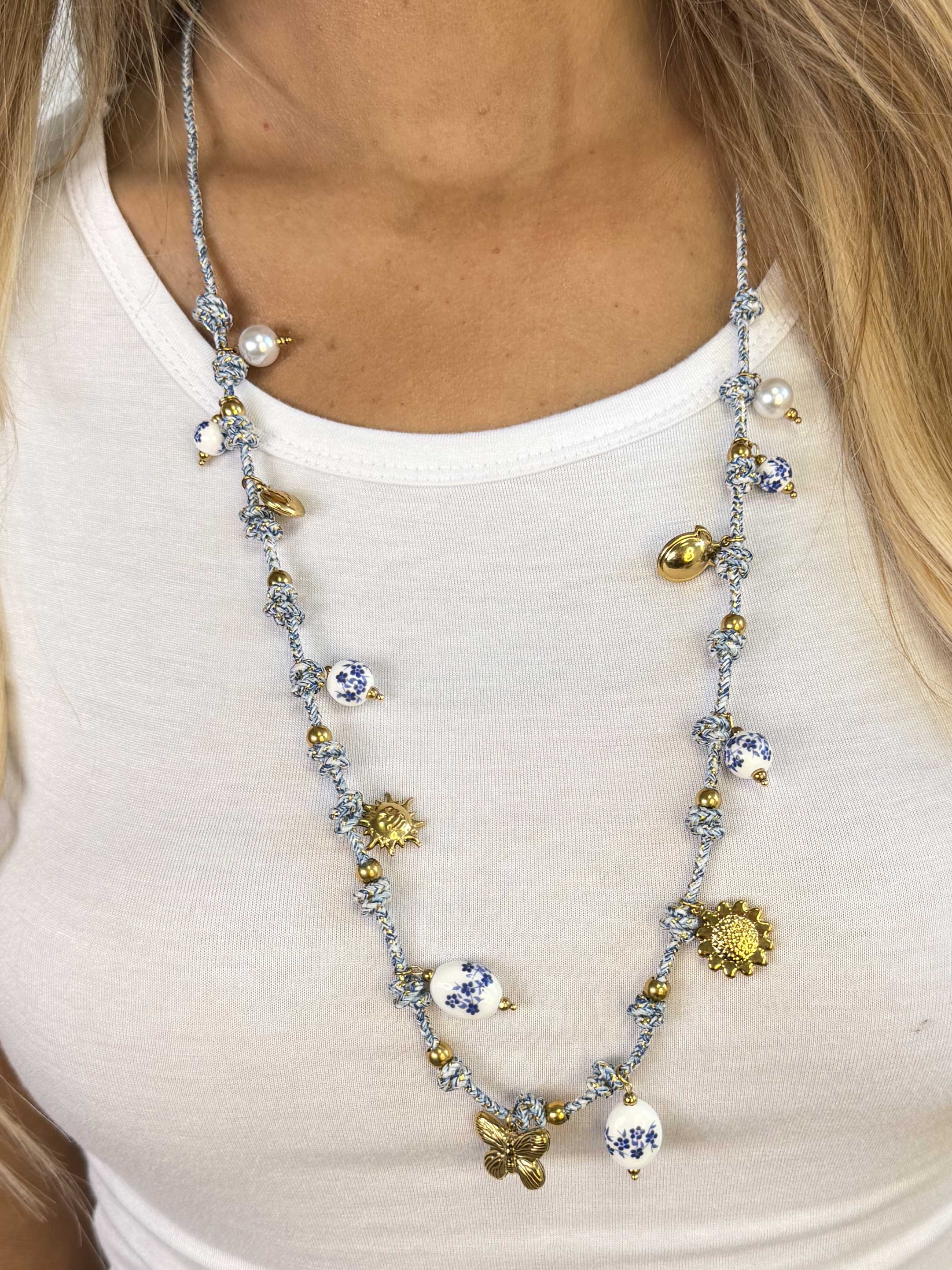 Roxan – Vitt och blått halsband med ett guldhänge och pärlor med blå blommor